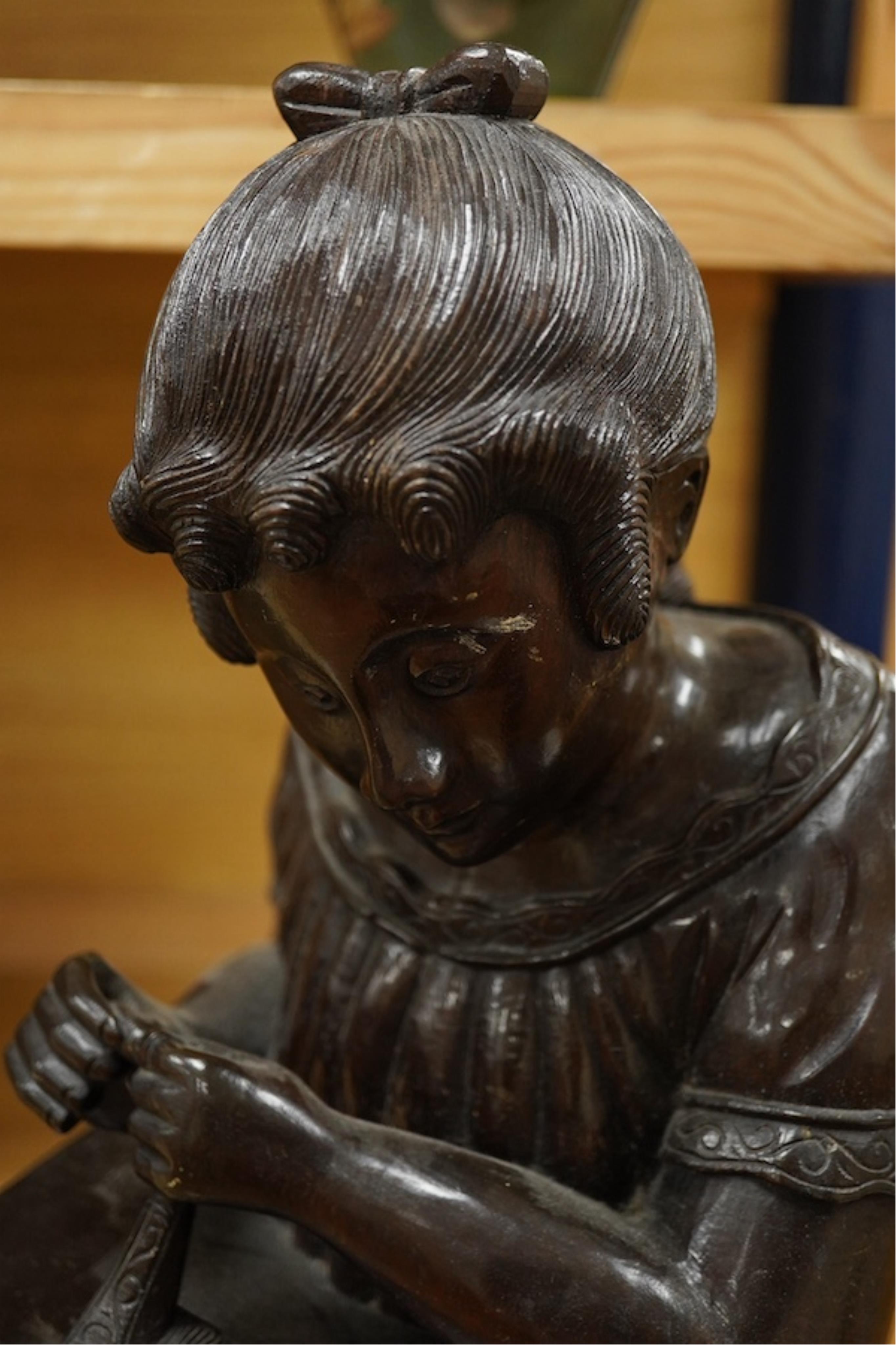 A carved wood bust of a girl sewing, 47cm high. Condition - two old cracks to the back of carving